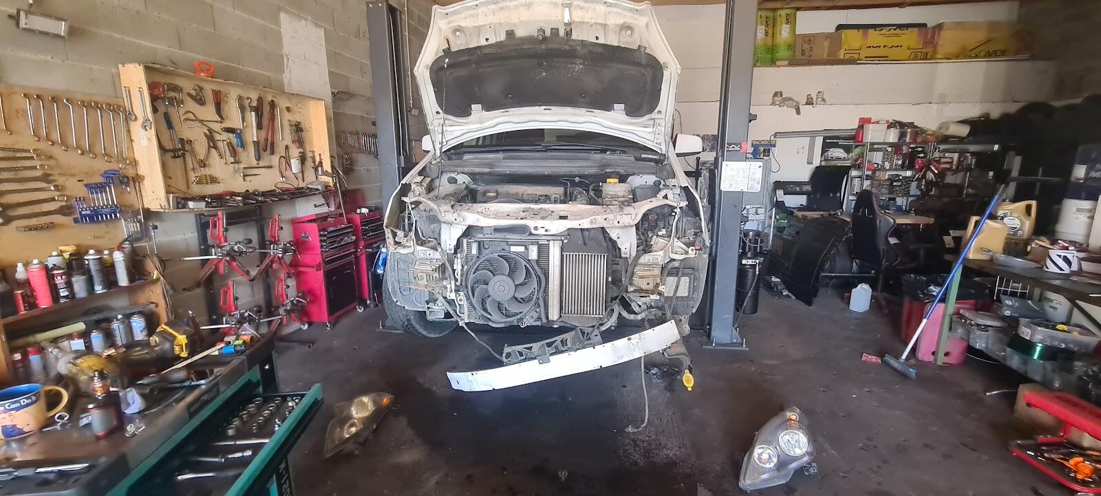 L'atelier d'Aurél auto à Crest : une voiture sur le pont, capot ouvert, le panneau d'outils et les servantes rouges