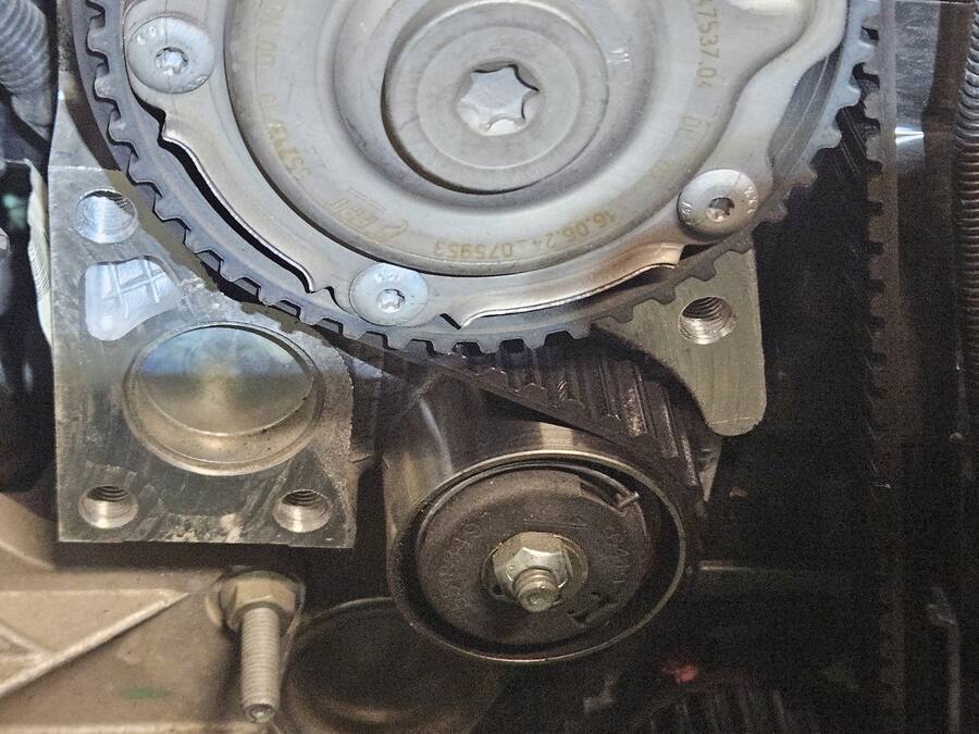 Courroie de distribution et poulie d'un moteur en cours de remplacement à l'atelier